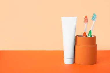 Arka planda diş fırçası ve yapıştırıcılı tutucu