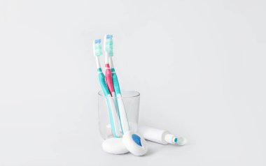 Beyaz arka planda diş fırçası, yapıştırma ve diş ipi olan tutucu