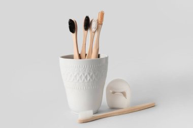 Beyaz arka planda diş fırçası ve diş ipi olan tutucu