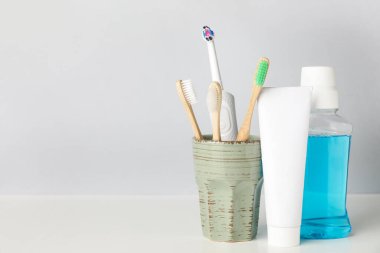 Farklı diş fırçalarına sahip tutucu, hafif arka planda durula ve yapıştır