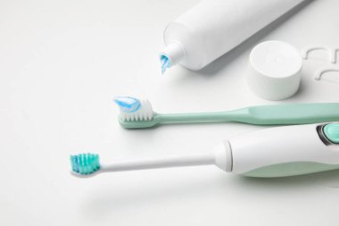 Beyaz arka planda farklı diş fırçaları ve yapıştırma