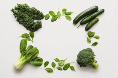 Beyaz arka planda taze yeşil sebzelerden yapılmış çerçeve