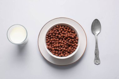 Çikolatalı mısır topları ve arka planda bir bardak süt.