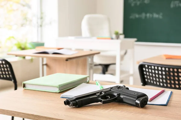 教室の机の上の銃 学校での銃撃の問題 — ストック写真