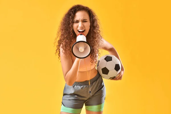 美丽的年轻女子 有扩音器和足球的色彩背景 — 图库照片