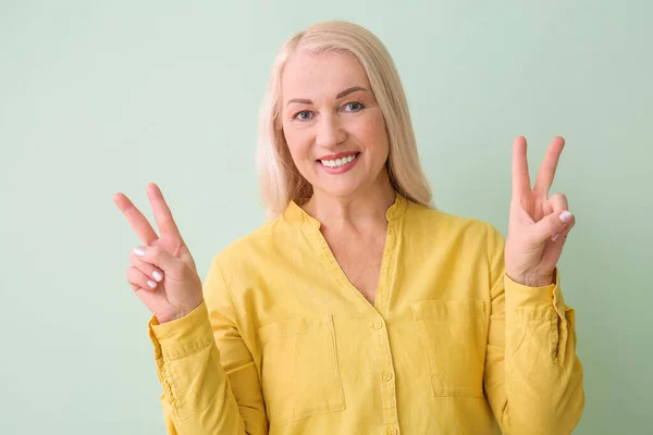 漂亮的成熟女人在色彩背景上表现出胜利的姿态 — 图库照片