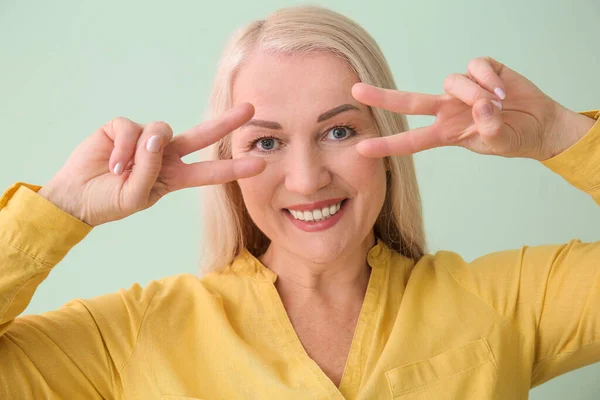 Vacker Mogen Kvinna Visar Seger Gest Färg Bakgrund Närbild — Stockfoto