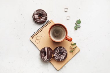 Hafif arka planda kahve ve çörek dolu bir defter.