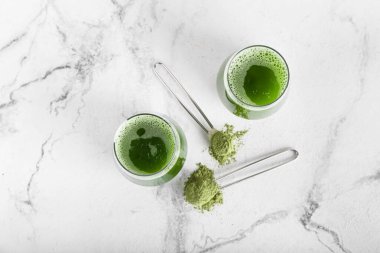 Hafif arka planda bir bardak kibrit çayı ve pudra.