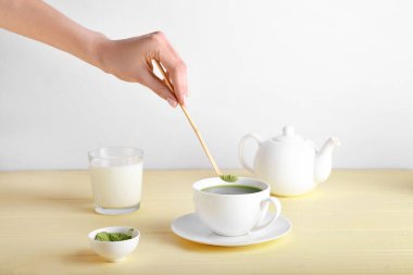 Kadın arka planda matcha çayı hazırlıyor