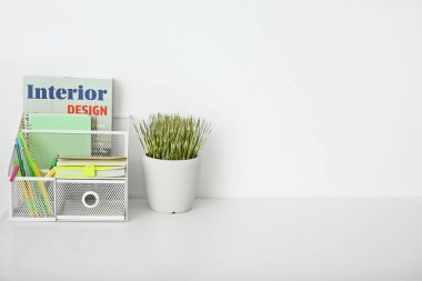 Masasında kırtasiye ve dergi bulunan şık bir organizatör.