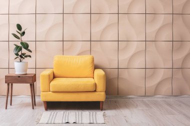 Koltuk ve ev bitkisi modern odanın içindeki masada.