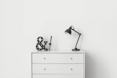 Çekmecelerin modern sandığı. Odada lamba var.