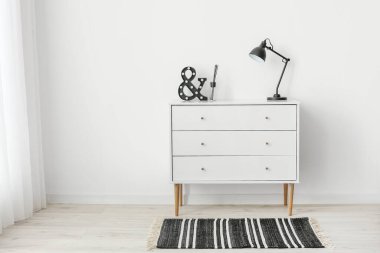 Çekmecelerin modern sandığı. Odada lamba var.