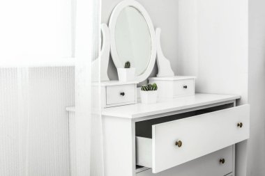 Ayna olan çekmeceler odada ışık duvarının yanında.