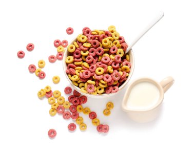 Lezzetli mısır gevreği ve beyaz arka planda bir sürahi süt.