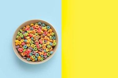 Arkaplanda mısır gevreği halkaları olan bir kase