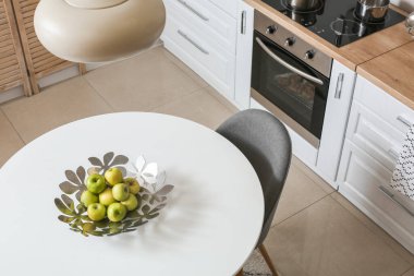 Modern mutfağın içinde elmalı yemek masası.