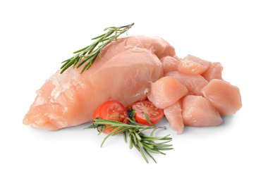 Beyaz arka planda domates ve biberiyeli çiğ tavuk filetosu.