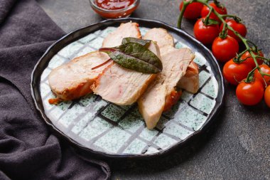 Lezzetli tavuk filetosu ve grunge arka planda domatesli tabak, yakın plan.