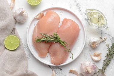 Hafif arka planda çiğ tavuk fileto tabağı.
