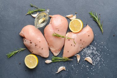 Koyu arkaplanda çiğ tavuk filetosu.