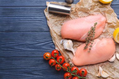 Koyu ahşap arka planda çiğ tavuk filetosu.