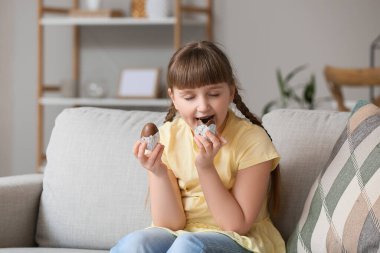 Evde çikolata yiyen tatlı küçük bir kız.