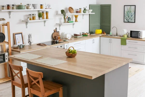 Modern mutfağın içinde elmalı yemek masası.