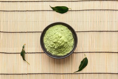 Bambu hasırında pudralanmış kibrit çayı ile kase