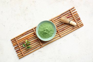 Pudralanmış kibrit çayı ve açık arkaplanda chasen ile kase