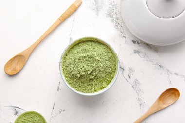 Hafif arkaplanda pudralı kibrit çayı, kaşıklar ve çaydanlık.