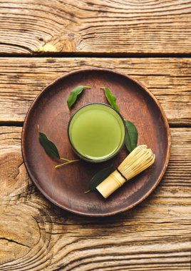 Bir bardak kibrit çayı ve ahşap arka planda şarap.