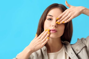 Renkli arka planda güzel manikürlü genç bir kadın.