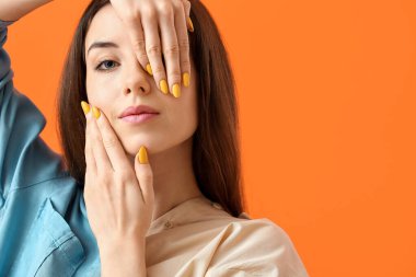 Renkli arka planda güzel manikürlü genç bir kadın.