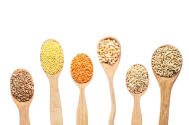 Farklı tahıllı kaşıklar ve beyaz arka planda baklagiller