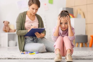 Evdeki psikoterapi seansında üzgün küçük kız.