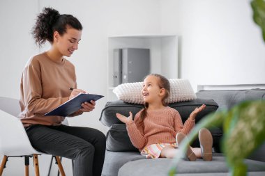 Ofiste küçük bir kızla çalışan kadın psikolog.