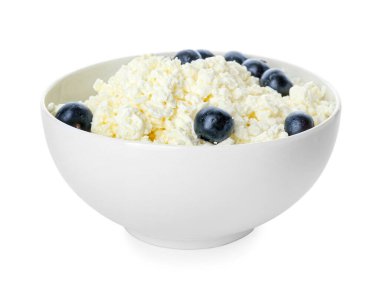 Beyaz arka planda yabanmersinli süzme peynir kasesi.