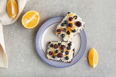 Süzme peynirli sandviçler, yaban mersini ve böğürtlen arkaplanda.