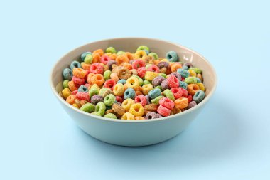 Arkaplanda mısır gevreği halkaları olan bir kase