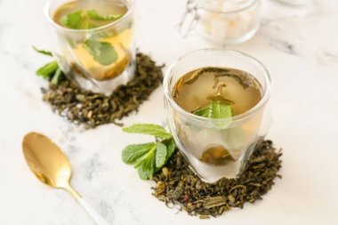 Açık arkaplanda bir fincan sıcak yeşil çay.