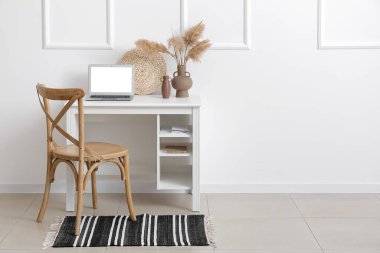 Odada, ışık duvarı yakınında rahat bir iş yeri.