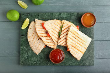 Lezzetli vejetaryen quesadilla, limon ve soslu ahşap arka plan.