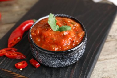 Ahşap zeminde bir kase lezzetli salsa sosu.