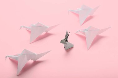 Origami turnaları ve renkli arka planda tavşan. Eşsizlik kavramı