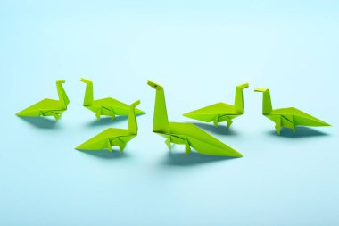 Origami dinozorları renk arkaplanda. Eşsizlik kavramı