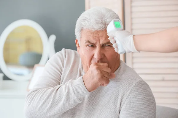 Doktor Evdeki Yaşlı Adamın Sıcaklığını Ölçüyor — Stok fotoğraf