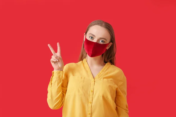 Stilvolle Junge Frau Trägt Maske Und Zeigt Siegesgeste Auf Farbigem — Stockfoto