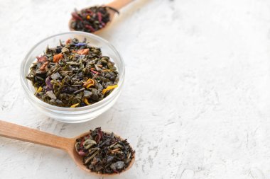 Kase ve kaşıklar, arka planda farklı türde kuru çay.